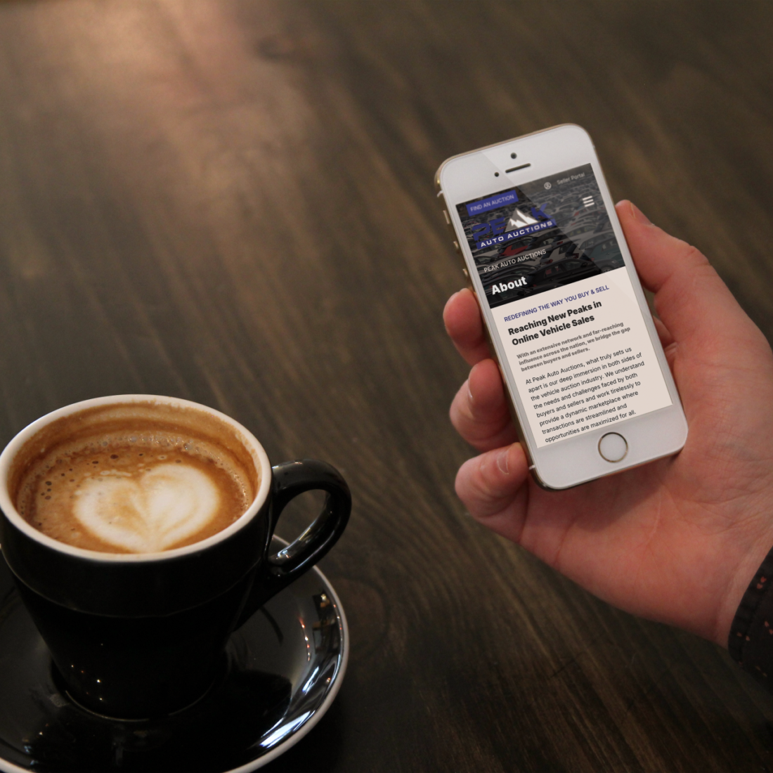 White iPhone SE on a wooden table, related to peak auto auction SEO project.